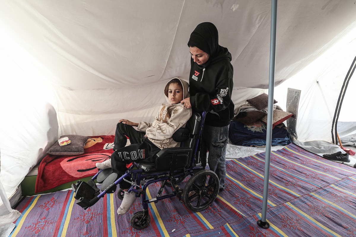 الطفل سيف رامي حجازي (13 عاما) أُصيب بشلل كامل وفشل كلوي إثر قصف إسرائيلي لخيمة عائلته، وتتولى والدته رعايته في ظروف إنسانية بالغة الصعوبة بمخيم المغازي، وسط قطاع غزة، 30 يناير/كانون الثاني 2026. صورة: معز صالحي