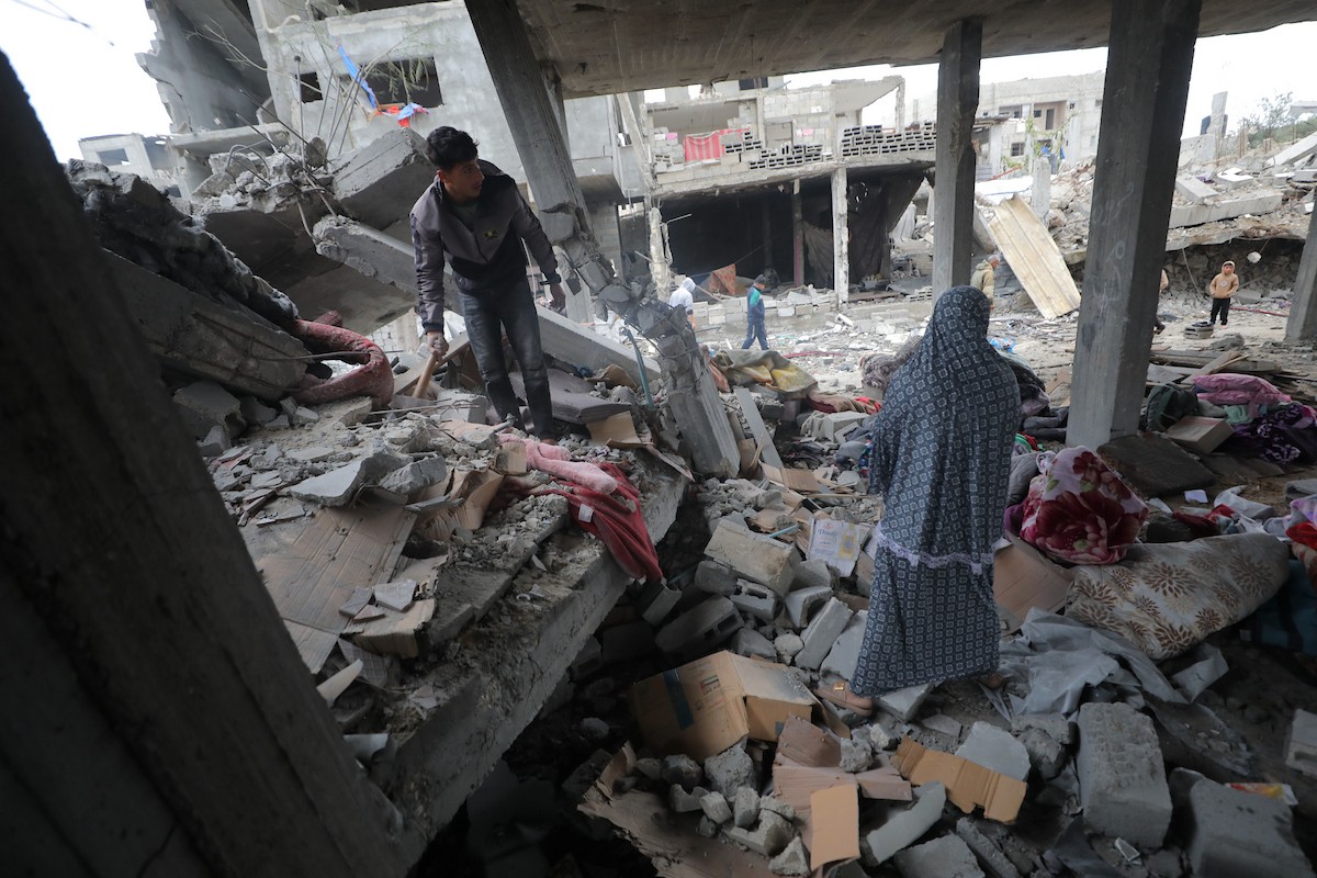 يبحث فلسطينيون عن ممتلكاتهم بين الأنقاض بعد أن دمرت غارات جوية إسرائيلية مبنى في مخيم البريج للاجئين وسط قطاع غزة. دمر الهجوم المبنى بالكامل وألحق أضرارًا بالمنشآت المحيطة به، 9 يناير/كانون الثاني 2026. صورة: معز صالحي