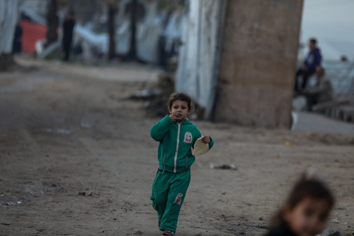 يسير فلسطينيون في شوارع مدينة غزة، وسط الأنقاض والدمار الذي خلفه الصراع الدائر، في 10 يناير/كانون الثاني 2026، بينما تستمر الحياة اليومية في ظل ظروف صعبة. صورة: عمر أشتوي