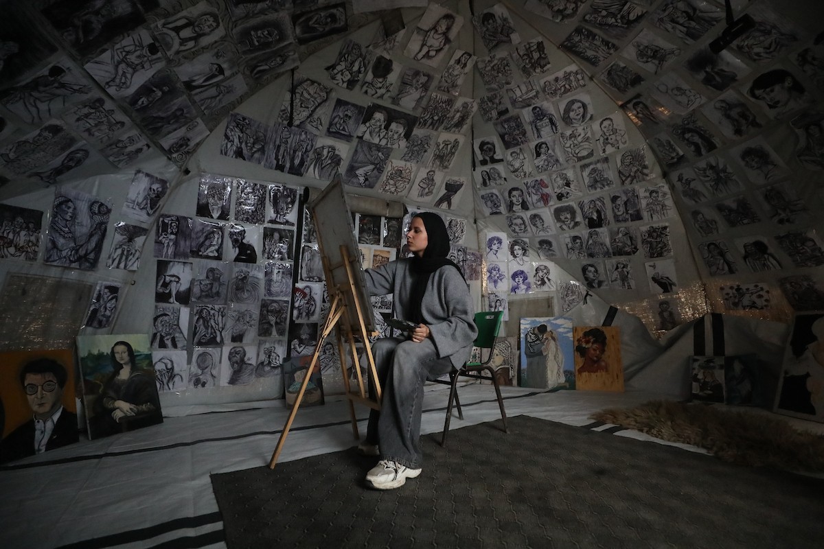 الفلسطينية مرَح خالد الزعانين (18 عاما) تحول خيمة نزوحها في مدينة غزة إلى معرض فني، 28 يناير/كانون الثاني 2026. تصوير: عمر أشتوي