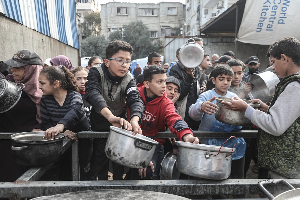 تلقى فلسطينيون، بينهم أطفال، وجبات ساخنة وزعتها إحدى الجمعيات الخيرية في مخيم النصيرات للاجئين، وسط نقص حاد في الغذاء ناجم عن الهجمات الإسرائيلية المستمرة وتدهور الأوضاع الإنسانية. النصيرات، وسط قطاع غزة. 26 يناير/كانون الثاني 2026. تصوير: معز صالحي