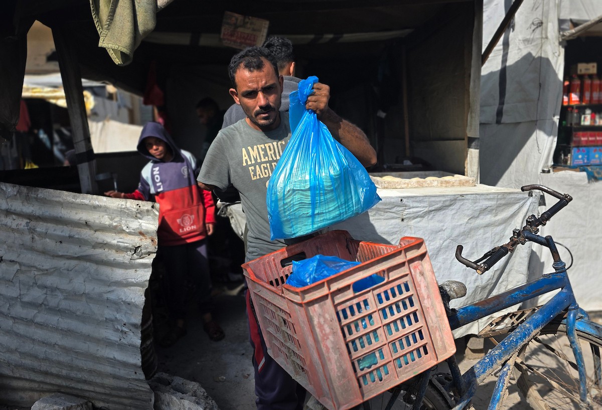 الفلسطيني محمد قحمان يعيد افتتاح مخبز تقليدي وسط أنقاض مدينة حمد غرب خان يونس، ويعمل جنباً إلى جنب مع أبنائه وصهره، وجميعهم من مبتوري الأطراف، 21 يناير/كانون الثاني 2026  . صورة: طارق محمد