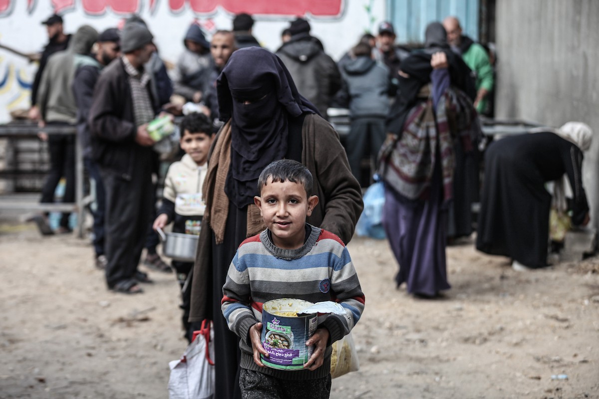 تجمع فلسطينيون نازحون داخلياً في مطبخ خيري لتلقي حصص غذائية محدودة وسط نقص حاد في الغذاء، في مخيم النصيرات للاجئين وسط قطاع غزة، 21 يناير/كانون الثاني 2026. صورة: معز صالحي