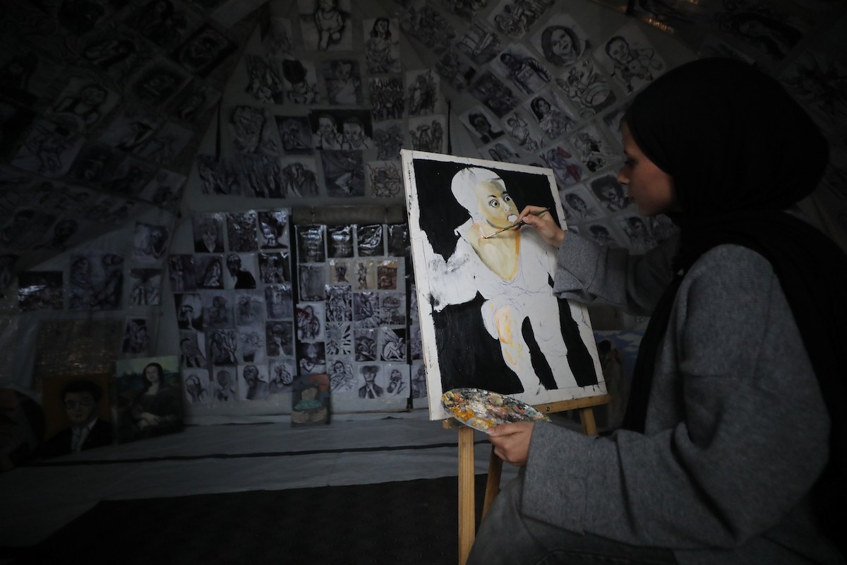 الفلسطينية مرَح خالد الزعانين (18 عاما) تحول خيمة نزوحها في مدينة غزة إلى معرض فني، 28 يناير/كانون الثاني 2026. تصوير: عمر أشتوي