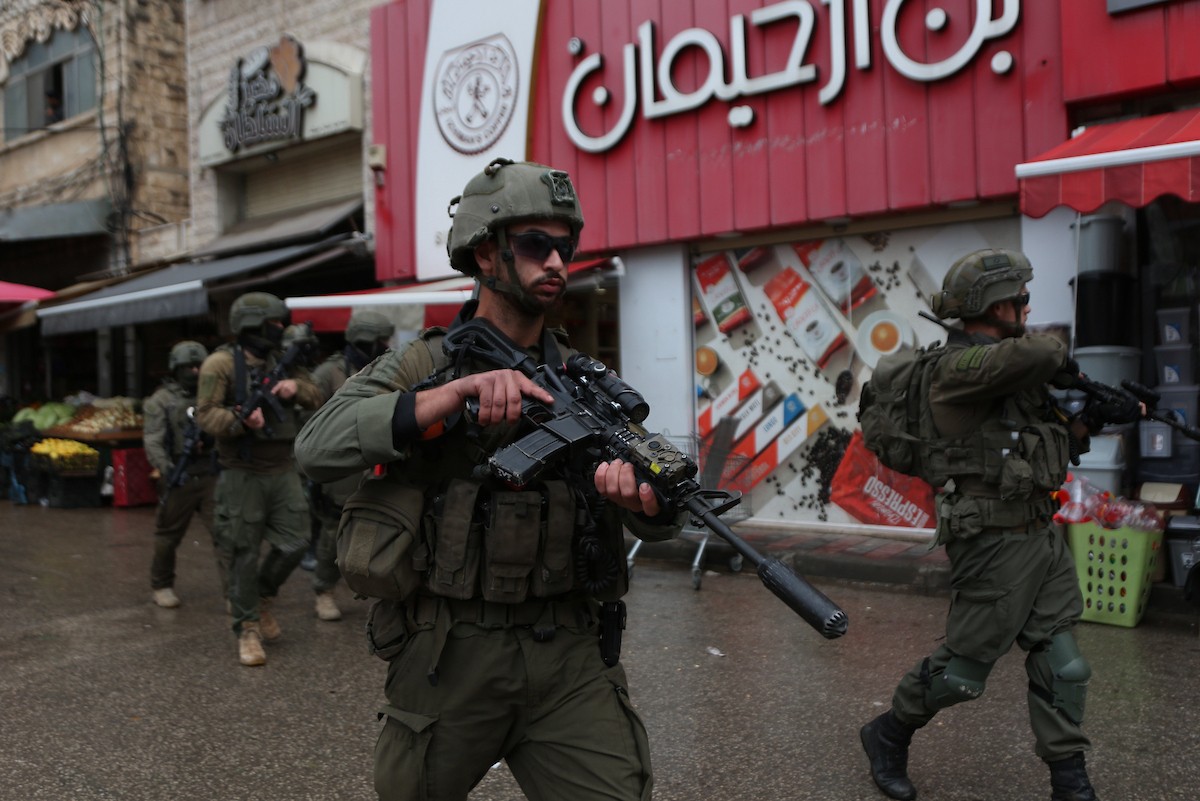 القوات الإسرائيلية تداهم عدد من المحال التجارية في السوق المركزي وتطلق النار تجاه بناية سكنية، وتوقف عدد من المواطنين في البلدة القديمة بمدينة نابلس، 1 يناير/كانون الثاني ٢٠٢٦. صورة: محمد ناصر