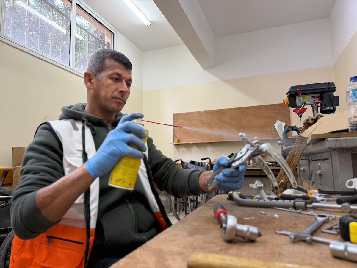 الفلسطيني رمزي الفجم يصلح كراسي متحركة لجرحى قطاع غزة متحديا إعاقته الشخصية ونقص المعدات الطبية ، خان يونس، جنوب قطاع غزة، 20 يناير/كانون الثاني 2026 تصوير: محمد سلامة / وكالة الأنباء الفلسطينية (APA Images)