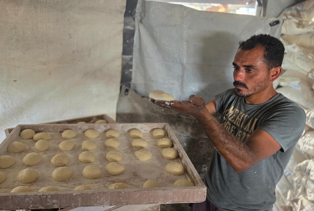الفلسطيني محمد قحمان يعيد افتتاح مخبز تقليدي وسط أنقاض مدينة حمد غرب خان يونس، ويعمل جنباً إلى جنب مع أبنائه وصهره، وجميعهم من مبتوري الأطراف، 21 يناير/كانون الثاني 2026  . صورة: طارق محمد