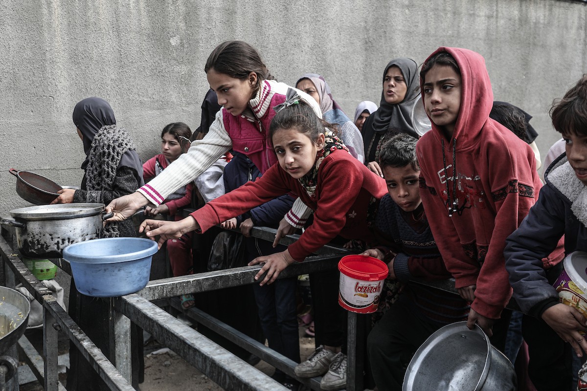 تجمع فلسطينيون نازحون داخلياً في مطبخ خيري لتلقي حصص غذائية محدودة وسط نقص حاد في الغذاء، في مخيم النصيرات للاجئين وسط قطاع غزة، 21 يناير/كانون الثاني 2026. صورة: معز صالحي