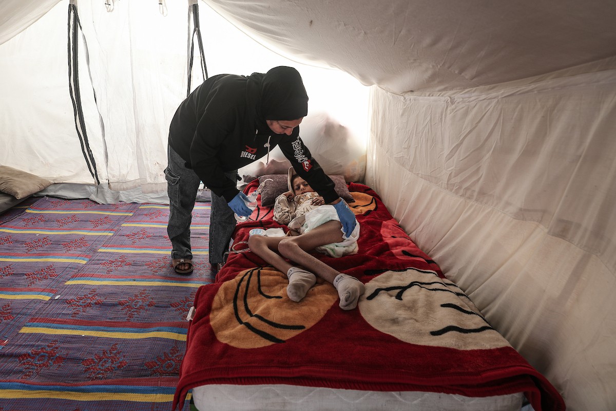 الطفل سيف رامي حجازي (13 عاما) أُصيب بشلل كامل وفشل كلوي إثر قصف إسرائيلي لخيمة عائلته، وتتولى والدته رعايته في ظروف إنسانية بالغة الصعوبة بمخيم المغازي، وسط قطاع غزة، 30 يناير/كانون الثاني 2026. صورة: معز صالحي