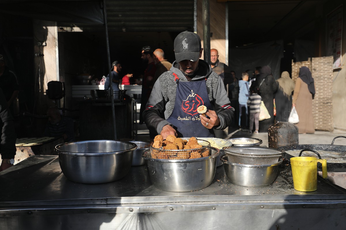 مشهد من الأسواق والبازارات في مخيم النصيرات، وسط قطاع غزة، حيث يستعد المواطنون للإفطار خلال شهر رمضان، في 22 فبراير/شباط 2026. تصوير: معز صالحي