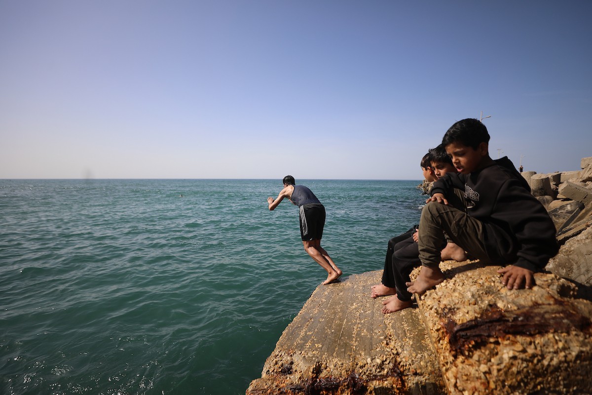 يسبح أطفال قرب ميناء غزة المدمر، في مشهد يعكس تمسكهم بلحظات الفرح رغم الدمار المحيط بهم. يُعدّ البحر في غزة المتنفس الوحيد لسكانها الذين يواجهون آثار الحرب والنزوح، والذين يعيشون في خيام تفتقر لأبسط مقومات الحياة، ١٢ فبراير ٢٠٢٦. تصوير: عمر أشتوي