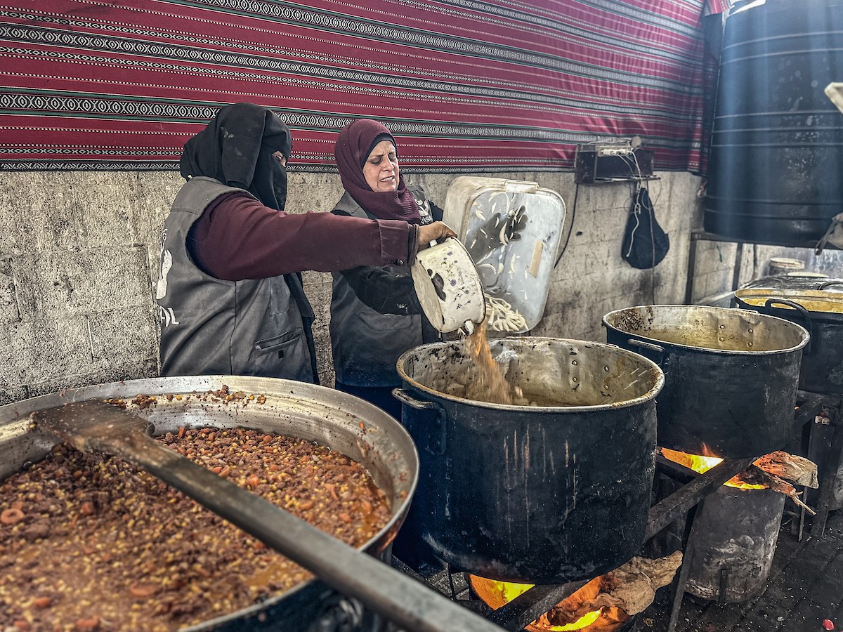 يتجمع فلسطينيون نازحون لتناول وجبة إفطارهم الرمضانية في مطبخ خيري بمخيم النصيرات للاجئين وسط قطاع غزة، في 24 فبراير/شباط 2026. ويواجه النازحون ظروفًا معيشية قاسية نتيجة انعدام الدخل ونقص المساعدات الإنسانية. (صورة: رمزي أبو عامر / apaimages)