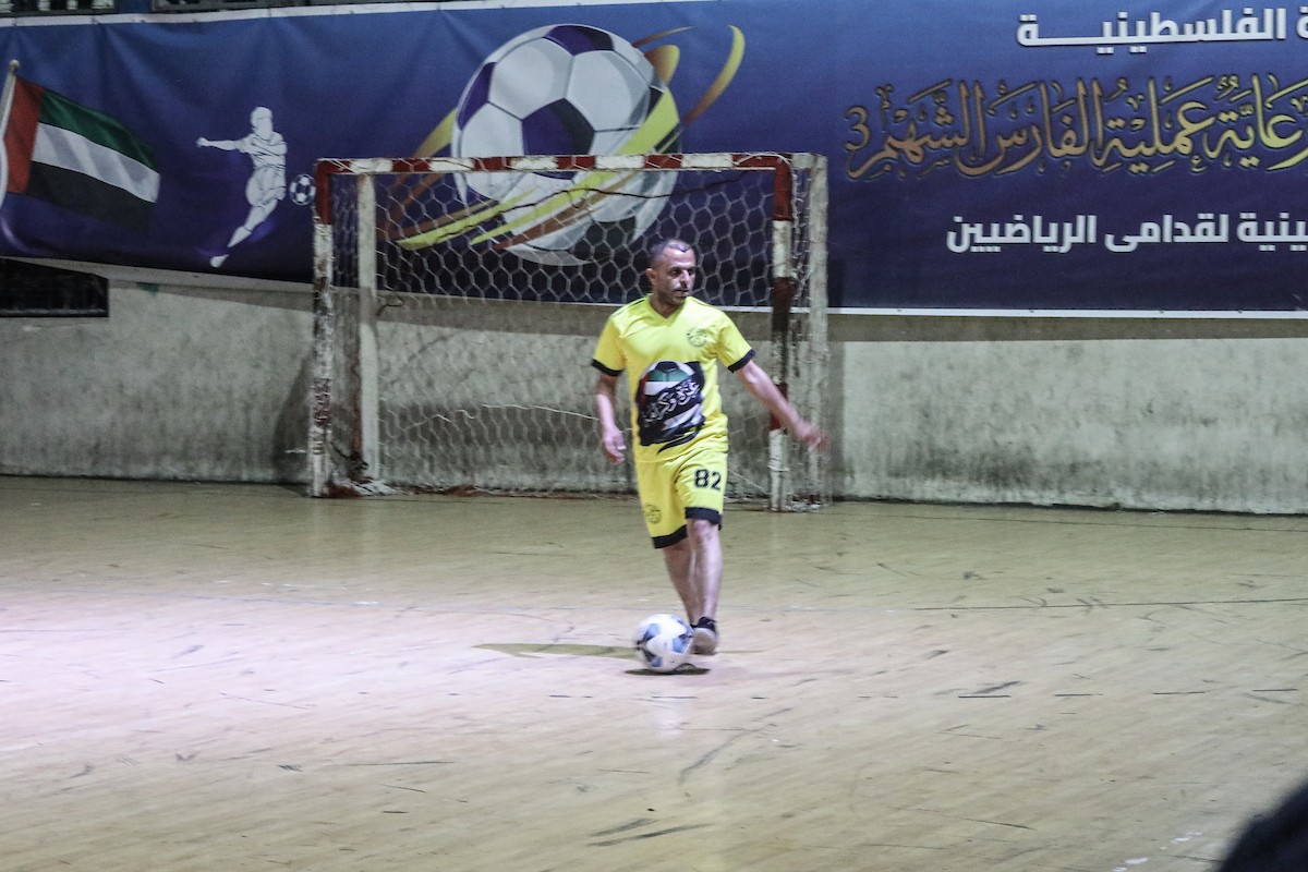 لاعبون فلسطينيون من فريقي النصيرات ورفح يتنافسون خلال مباراة كرة قدم على ملعب نادي خدمات النصيرات، ضمن بطولة غزة الرمضانية، بحضور حشد جماهيري كبير، في مخيم النصيرات بوسط قطاع غزة، بتاريخ 21 فبراير/شباط 2026. تصوير: معز صالحي / apaimages