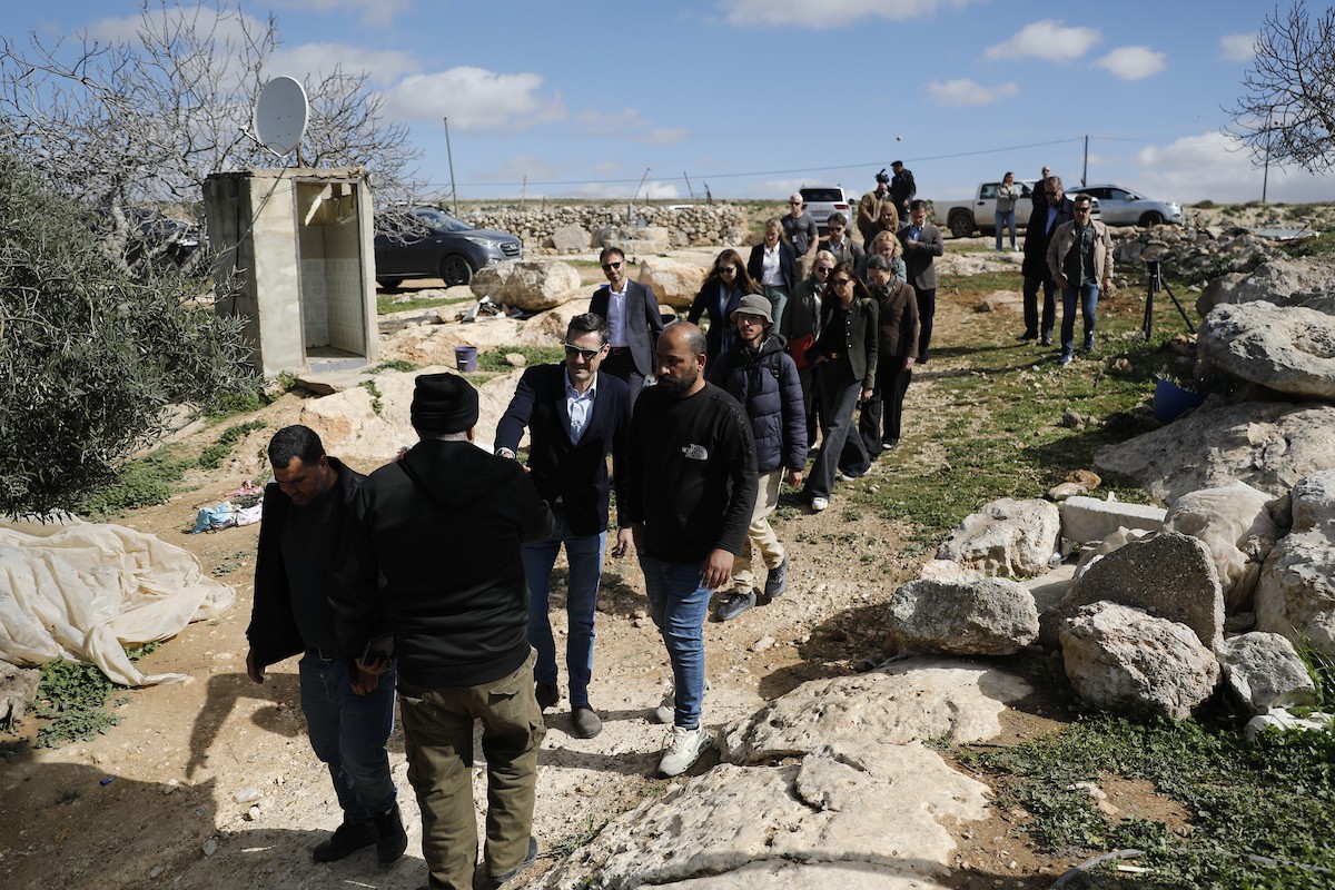 وفد دبلوماسي أوروبي يزور قرية سوسيا، جنوب الخليل، لتقييم الأضرار التي لحقت بالممتلكات الفلسطينية جراء هجمات المستوطنين، 25 فبراير/شباط 2026. تصوير: مأمون وزواز