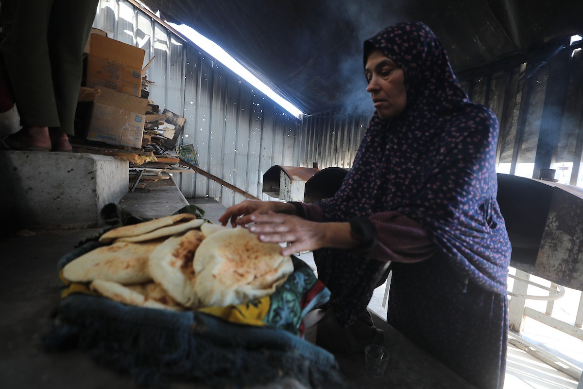 مجموعة من النساء يعملن داخل مخبز أُنشئ في مخيم اليرموك للاجئين بمدينة غزة، ضمن مبادرة إنسانية بالشراكة مع اللجنة الدولية للصليب الأحمر. تهدف المبادرة إلى تخفيف الأعباء المعيشية عن النساء النازحات، لا سيما خلال شهر رمضان. مدينة غزة، 25 فبراير/شباط 2026. تصوير: عمر أشتوي