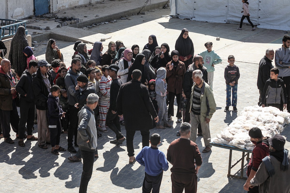 نساء فلسطينيات، زوجات شهداء الحرب، يُجهّزن الخبز لتوزيعه على العائلات النازحة والمحتاجة في مخيم البريج للاجئين وسط قطاع غزة خلال شهر رمضان، في مشهد يُجسّد روح التضامن والصمود في ظلّ الظروف الإنسانية الصعبة، فبراير/شباط 2026. تصوير: معز صالحي