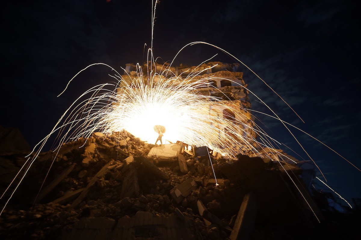 فلسطينيون يُشعلون شرارات من الصوف الفولاذي ( الليف السلكي) خلال شهر رمضان المبارك، وسط أنقاض المباني السكنية التي دُمّرت خلال العدوان الإسرائيلي الذي استمر عامين، في مدينة غزة، 23 فبرايرشباط 2026. صورة عمر أشتوي