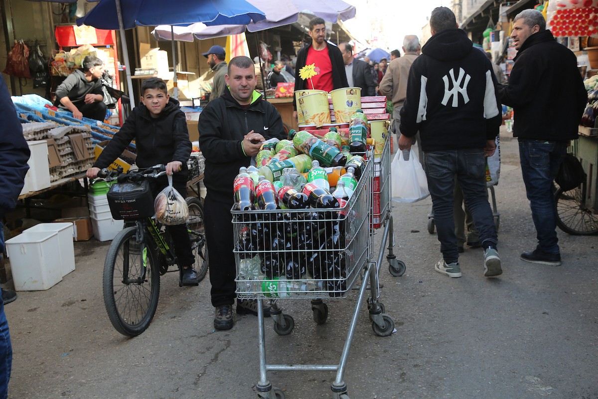 فلسطينيون يتسوقون استعدادًا للإفطار في أول أيام شهر رمضان المبارك، في مدينة نابلس بالضفة الغربية، 18 فبراير/شباط 2026. صورة: محمد ناصر