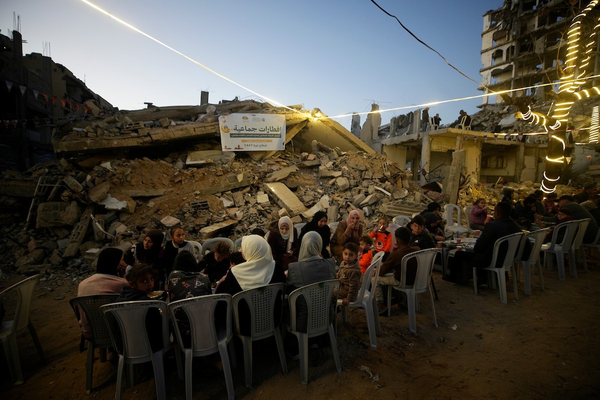 يتجمع الفلسطينيون بين المنازل المدمرة لتناول وجبة الإفطار معًا خلال شهر رمضان المبارك في شمال قطاع غزة، 22 فبراير/شباط 2026. صورة: عمر أشتوي