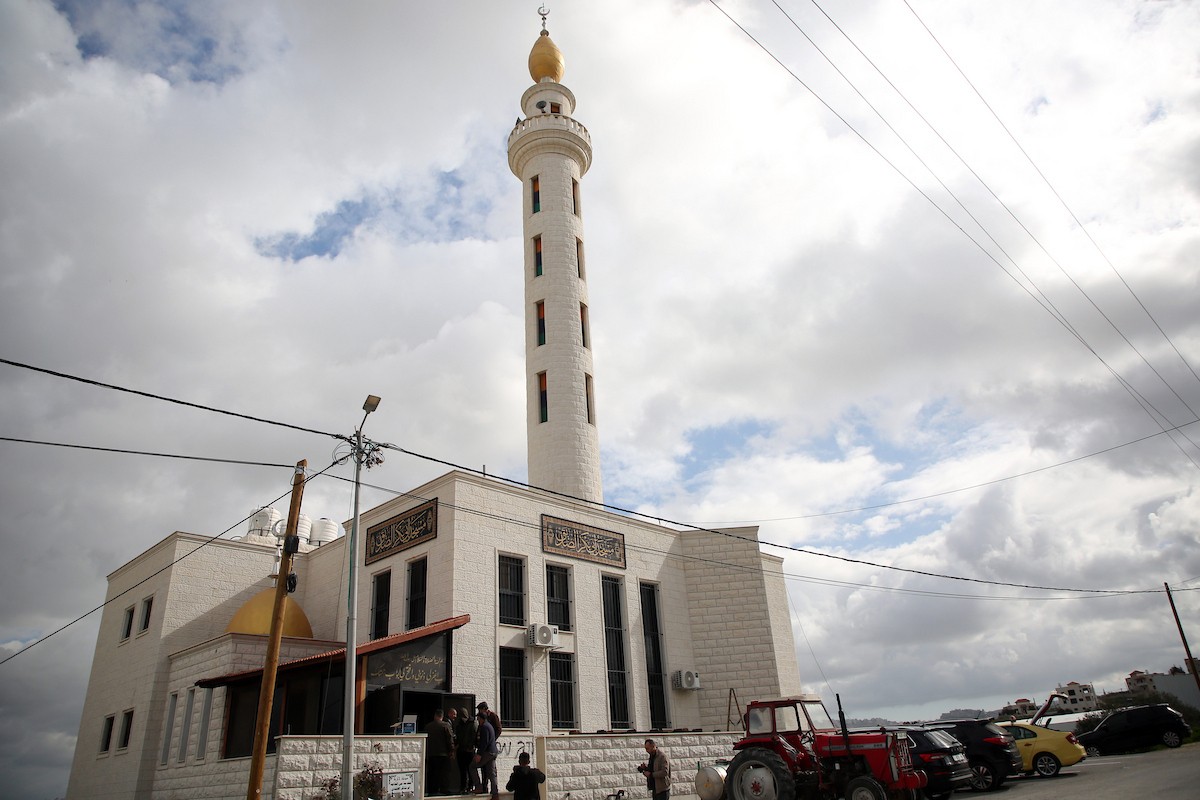 يتفقد فلسطينيون المدخل المحترق لمسجد أبو بكر الصديق في قرية تل، غرب نابلس بالضفة الغربية، في 23 فبراير/شباط 2026، عقب هجوم نُسب إلى مستوطنين يهود. صورة: محمد ناصر