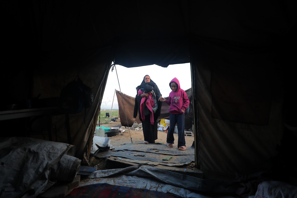 عائلة فلسطينية كفيفة تتناول وجبة الإفطار خارج خيمتها في مخيم بوسط قطاع غزة خلال شهر رمضان