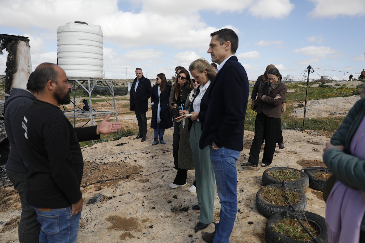 وفد دبلوماسي أوروبي يزور قرية سوسيا، جنوب الخليل، لتقييم الأضرار التي لحقت بالممتلكات الفلسطينية جراء هجمات المستوطنين، 25 فبراير/شباط 2026. تصوير: مأمون وزواز