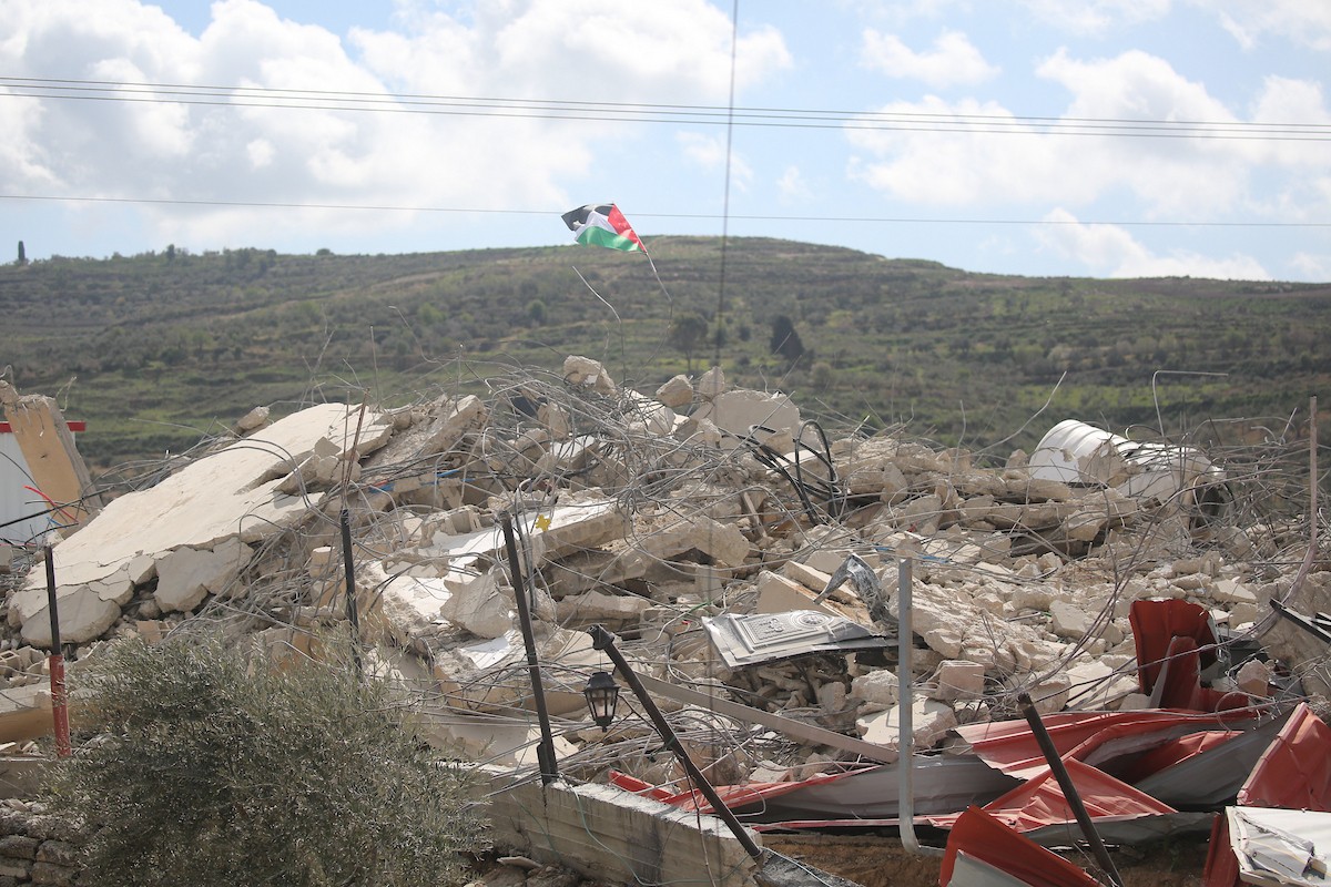 فلسطينيون يتفقدون منزلاً بعد هدمه على يد قوات الجيش الإسرائيلي في قرية عنزة، جنوب جنين بالضفة الغربية. ٢٥ فبراير ٢٠٢٦. صورة: محمد ناصر