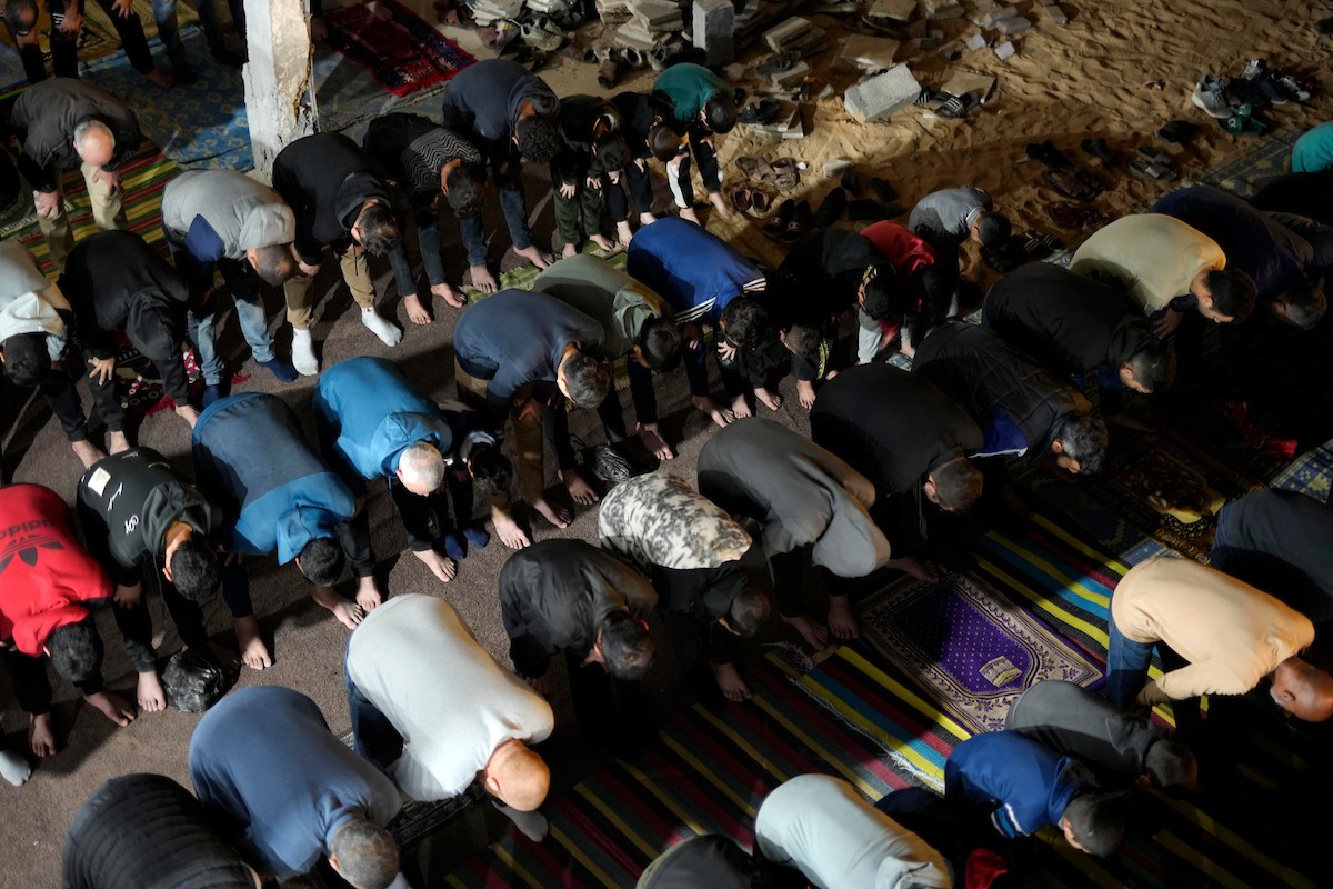 فلسطينيون يؤدون صلاة التراويح في أول ليلة من شهر رمضان على أنقاض مسجد الكنز المدمر في مدينة غزة، في 17 فبراير/شباط 2026. وكان مفتي القدس والأراضي الفلسطينية قد أعلن أن يوم الأربعاء 18 فبراير/شباط 2026 هو أول أيام رمضان. (صورة: عمر أشتوي)