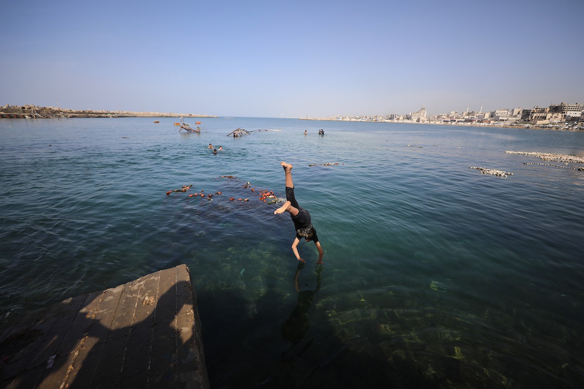 يسبح أطفال قرب ميناء غزة المدمر، في مشهد يعكس تمسكهم بلحظات الفرح رغم الدمار المحيط بهم. يُعدّ البحر في غزة المتنفس الوحيد لسكانها الذين يواجهون آثار الحرب والنزوح، والذين يعيشون في خيام تفتقر لأبسط مقومات الحياة، ١٢ فبراير ٢٠٢٦. تصوير: عمر أشتوي