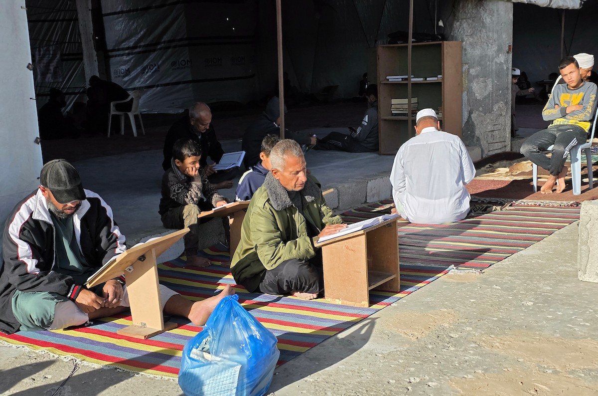 فلسطينيون، بينهم أطفال، يتلون ويحفظون القرآن الكريم خلال شهر رمضان داخل مسجد الألباني، الذي تضرر بشدة جراء الهجمات الإسرائيلية، في خان يونس، جنوب قطاع غزة، في 23 فبراير/شباط 2026. صورة: طارق محمد