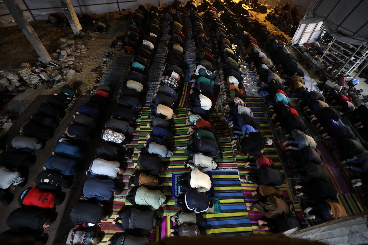 فلسطينيون يؤدون صلاة التراويح في أول ليلة من شهر رمضان على أنقاض مسجد الكنز المدمر في مدينة غزة، في 17 فبراير/شباط 2026. وكان مفتي القدس والأراضي الفلسطينية قد أعلن أن يوم الأربعاء 18 فبراير/شباط 2026 هو أول أيام رمضان. (صورة: عمر أشتوي)