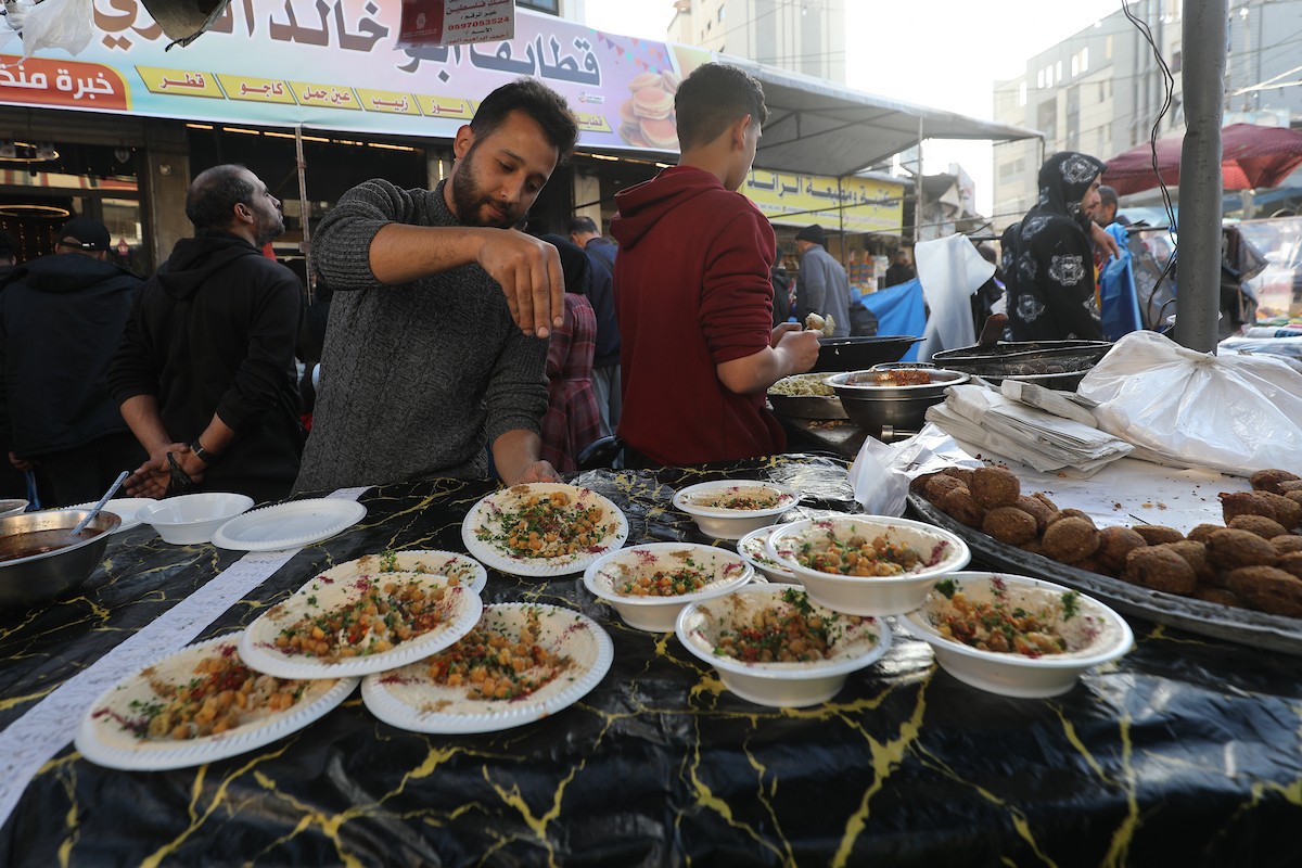 مشهد من الأسواق والبازارات في مخيم النصيرات، وسط قطاع غزة، حيث يستعد المواطنون للإفطار خلال شهر رمضان، في 22 فبراير/شباط 2026. تصوير: معز صالحي