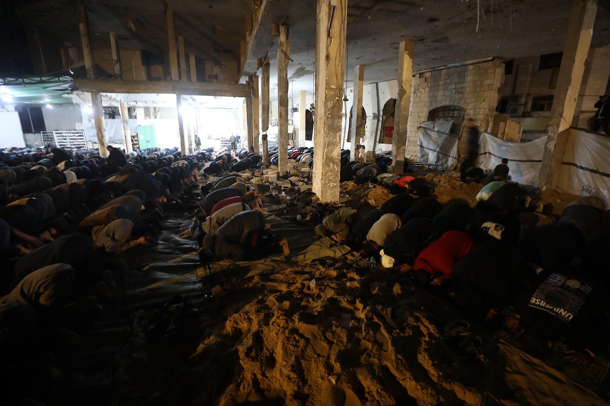 فلسطينيون يؤدون صلاة التراويح في أول ليلة من شهر رمضان على أنقاض مسجد الكنز المدمر في مدينة غزة، في 17 فبراير/شباط 2026. وكان مفتي القدس والأراضي الفلسطينية قد أعلن أن يوم الأربعاء 18 فبراير/شباط 2026 هو أول أيام رمضان. (صورة: عمر أشتوي)