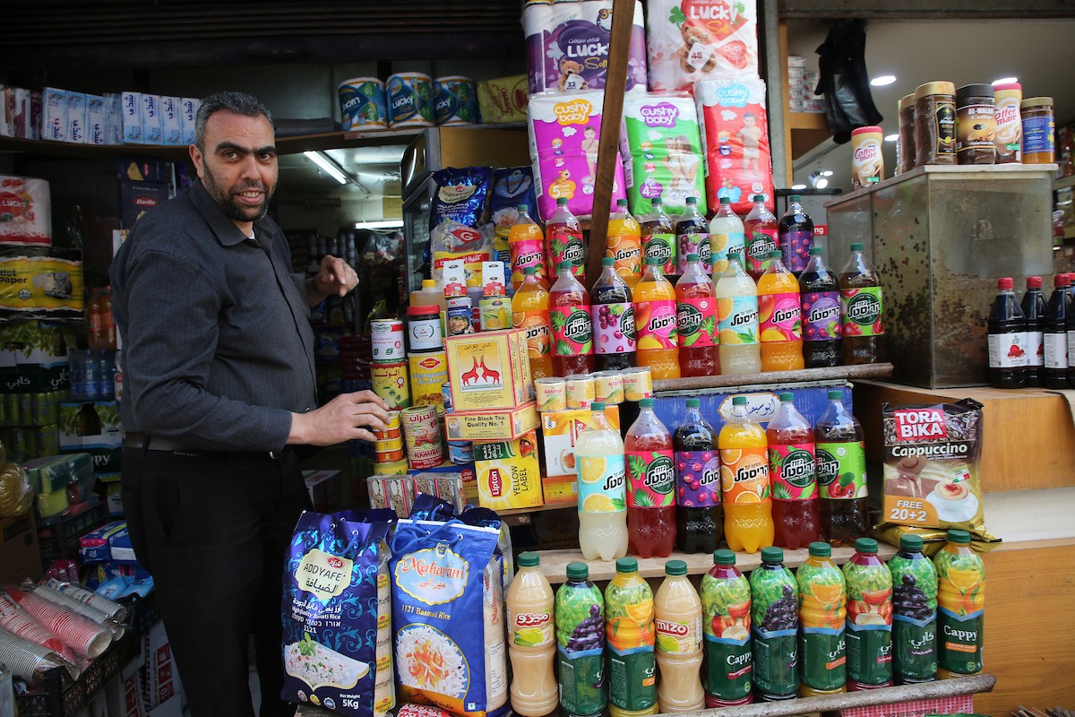 فلسطينيون يتسوقون استعدادًا للإفطار في أول أيام شهر رمضان المبارك، في مدينة نابلس بالضفة الغربية، 18 فبراير/شباط 2026. صورة: محمد ناصر