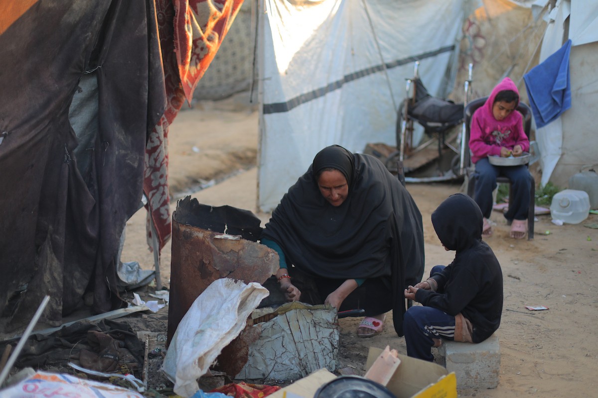 عائلة فلسطينية كفيفة تتناول وجبة الإفطار خارج خيمتها في مخيم بوسط قطاع غزة خلال شهر رمضان