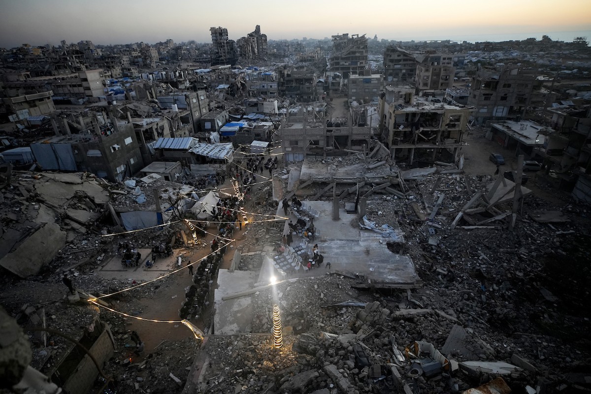 يتجمع الفلسطينيون بين المنازل المدمرة لتناول وجبة الإفطار معًا خلال شهر رمضان المبارك في شمال قطاع غزة، 22 فبراير/شباط 2026. صورة: عمر أشتوي