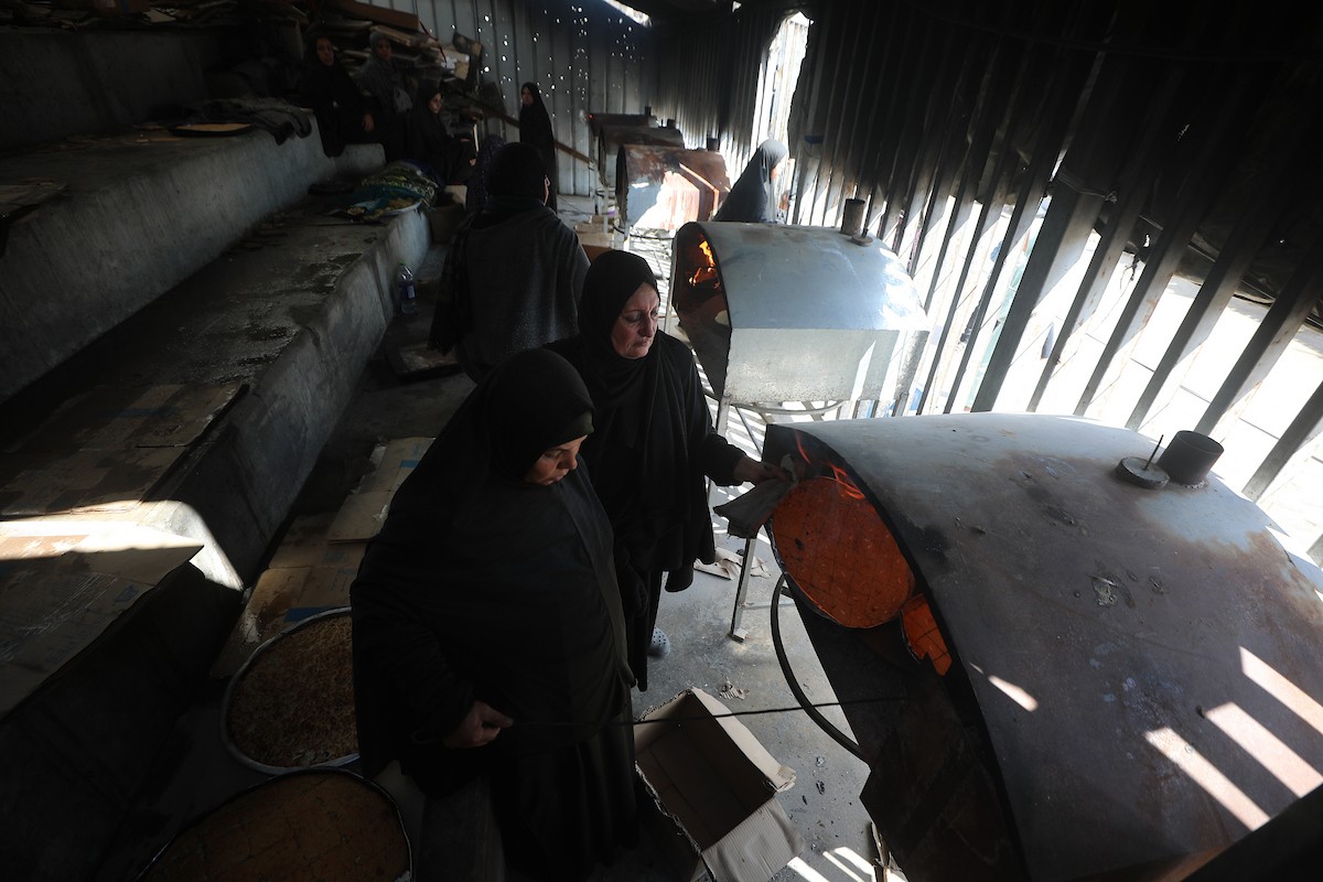 مجموعة من النساء يعملن داخل مخبز أُنشئ في مخيم اليرموك للاجئين بمدينة غزة، ضمن مبادرة إنسانية بالشراكة مع اللجنة الدولية للصليب الأحمر. تهدف المبادرة إلى تخفيف الأعباء المعيشية عن النساء النازحات، لا سيما خلال شهر رمضان. مدينة غزة، 25 فبراير/شباط 2026. تصوير: عمر أشتوي