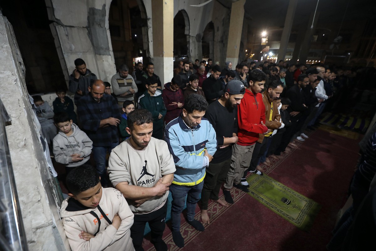 فلسطينيون يؤدون صلاة التراويح في أول ليلة من شهر رمضان على أنقاض مسجد الكنز المدمر في مدينة غزة، في 17 فبراير/شباط 2026. وكان مفتي القدس والأراضي الفلسطينية قد أعلن أن يوم الأربعاء 18 فبراير/شباط 2026 هو أول أيام رمضان. (صورة: عمر أشتوي)