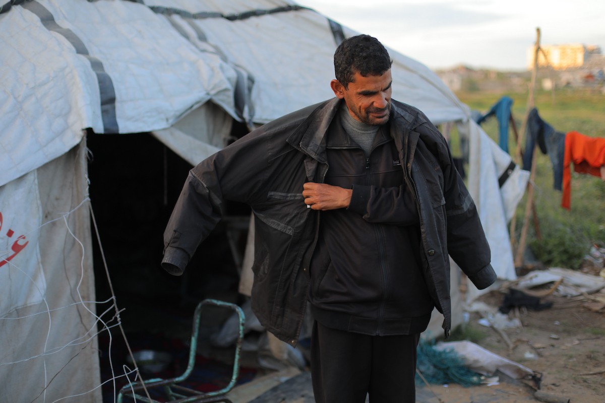 عائلة فلسطينية كفيفة تتناول وجبة الإفطار خارج خيمتها في مخيم بوسط قطاع غزة خلال شهر رمضان