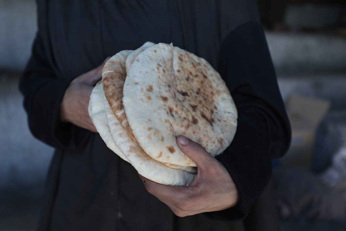 مجموعة من النساء يعملن داخل مخبز أُنشئ في مخيم اليرموك للاجئين بمدينة غزة، ضمن مبادرة إنسانية بالشراكة مع اللجنة الدولية للصليب الأحمر. تهدف المبادرة إلى تخفيف الأعباء المعيشية عن النساء النازحات، لا سيما خلال شهر رمضان. مدينة غزة، 25 فبراير/شباط 2026. تصوير: عمر أشتوي