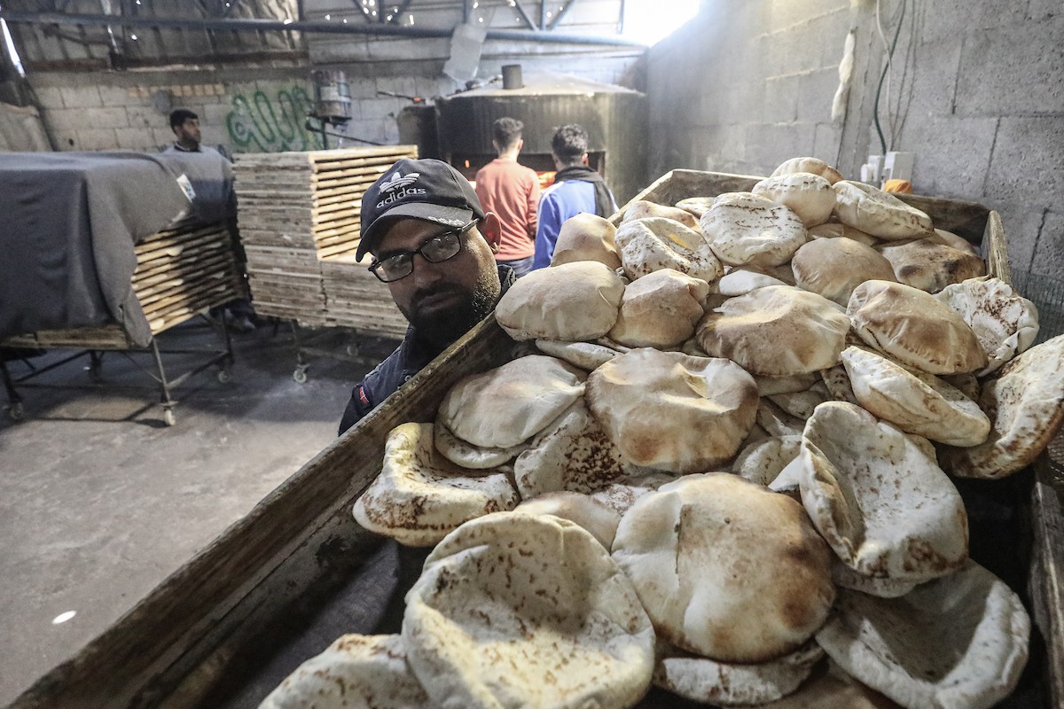 نساء فلسطينيات، زوجات شهداء الحرب، يُجهّزن الخبز لتوزيعه على العائلات النازحة والمحتاجة في مخيم البريج للاجئين وسط قطاع غزة خلال شهر رمضان، في مشهد يُجسّد روح التضامن والصمود في ظلّ الظروف الإنسانية الصعبة، فبراير/شباط 2026. تصوير: معز صالحي