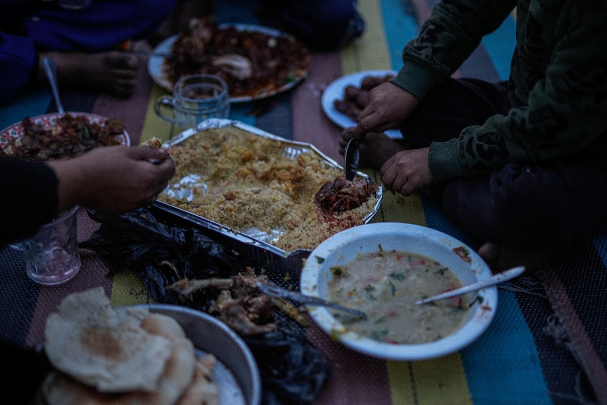 عائلة فلسطينية نازحة من بيت حانون تفطر في ثاني أيام رمضان في خيمة متداعية وسط أنقاض مسجد الحساينة على شاطئ مدينة غزة.19 فبراير/شباط 2026. تصوير: عمر أشتوي