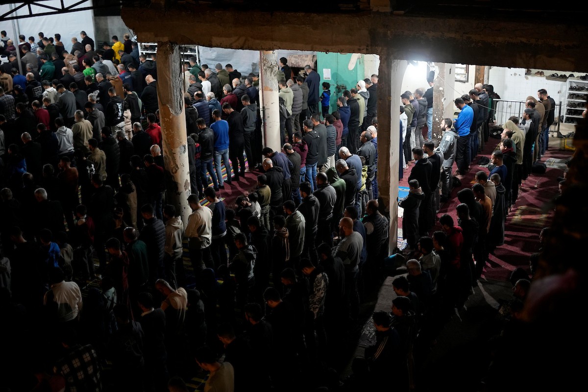 فلسطينيون يؤدون صلاة التراويح في أول ليلة من شهر رمضان على أنقاض مسجد الكنز المدمر في مدينة غزة، في 17 فبراير/شباط 2026. وكان مفتي القدس والأراضي الفلسطينية قد أعلن أن يوم الأربعاء 18 فبراير/شباط 2026 هو أول أيام رمضان. (صورة: عمر أشتوي)