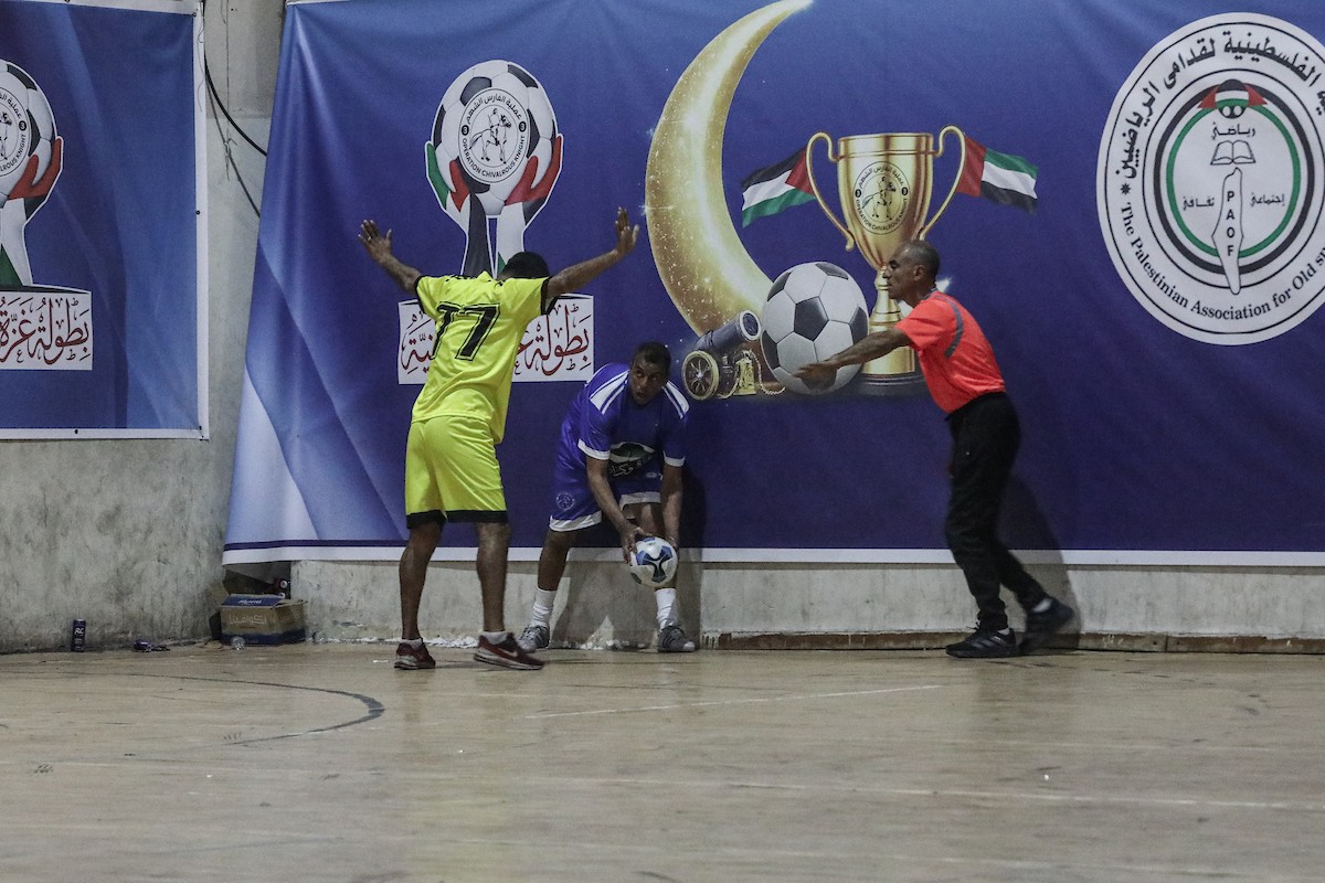 لاعبون فلسطينيون من فريقي النصيرات ورفح يتنافسون خلال مباراة كرة قدم على ملعب نادي خدمات النصيرات، ضمن بطولة غزة الرمضانية، بحضور حشد جماهيري كبير، في مخيم النصيرات بوسط قطاع غزة، بتاريخ 21 فبراير/شباط 2026. تصوير: معز صالحي / apaimages