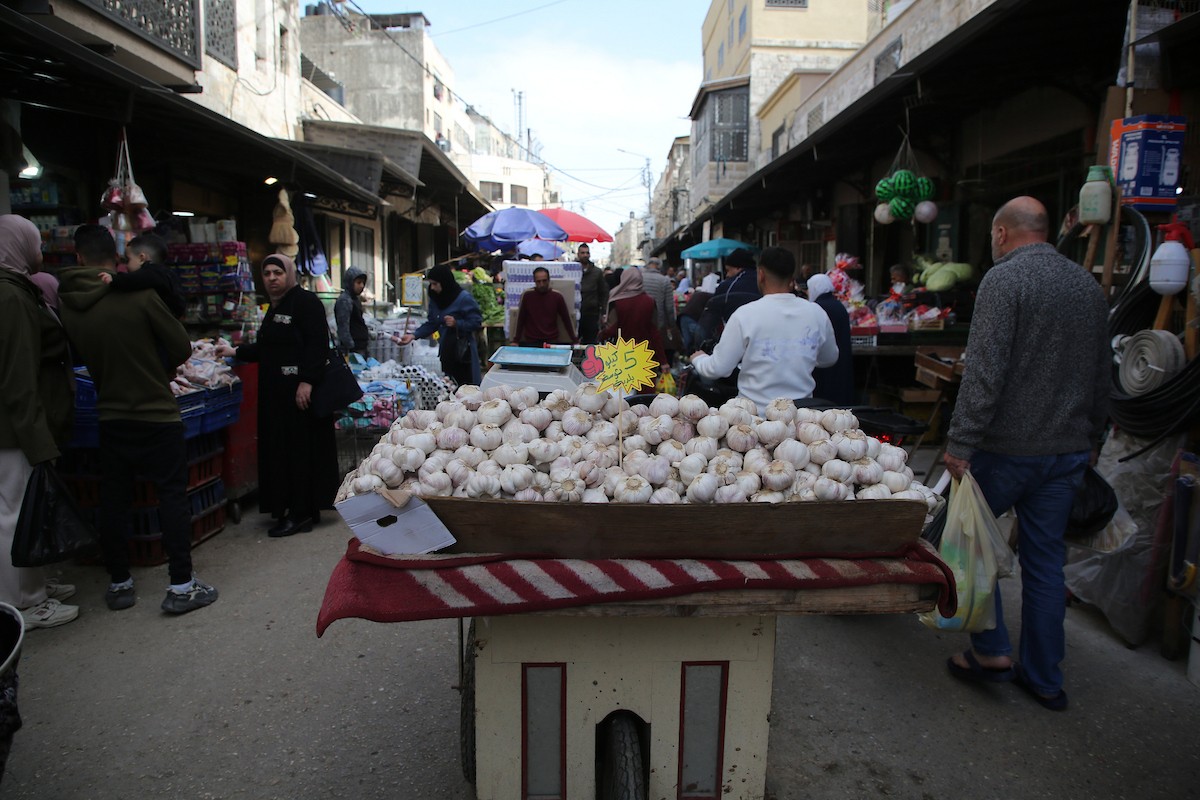 فلسطينيون يتسوقون استعدادًا للإفطار في أول أيام شهر رمضان المبارك، في مدينة نابلس بالضفة الغربية، 18 فبراير/شباط 2026. صورة: محمد ناصر