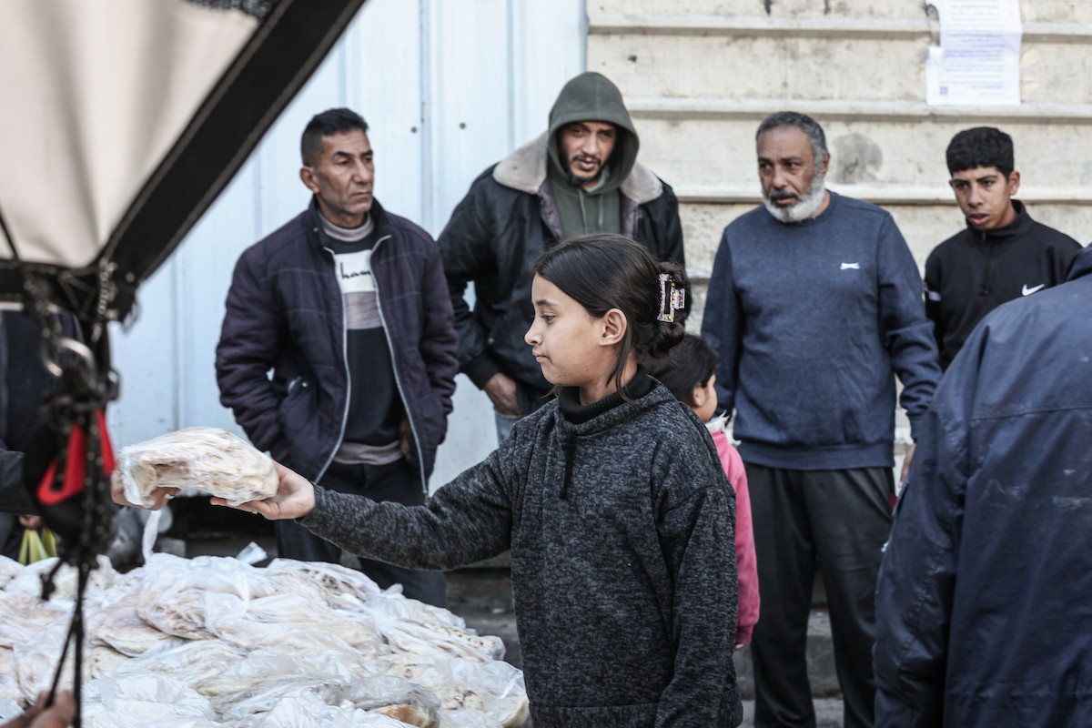 نساء فلسطينيات، زوجات شهداء الحرب، يُجهّزن الخبز لتوزيعه على العائلات النازحة والمحتاجة في مخيم البريج للاجئين وسط قطاع غزة خلال شهر رمضان، في مشهد يُجسّد روح التضامن والصمود في ظلّ الظروف الإنسانية الصعبة، فبراير/شباط 2026. تصوير: معز صالحي