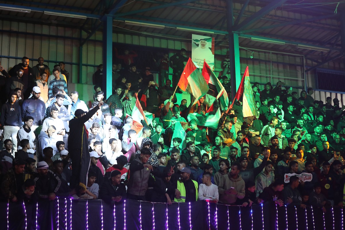 لاعبون فلسطينيون من فريقي النصيرات ورفح يتنافسون خلال مباراة كرة قدم على ملعب نادي خدمات النصيرات، ضمن بطولة غزة الرمضانية، بحضور حشد جماهيري كبير، في مخيم النصيرات بوسط قطاع غزة، بتاريخ 21 فبراير/شباط 2026. تصوير: معز صالحي / apaimages