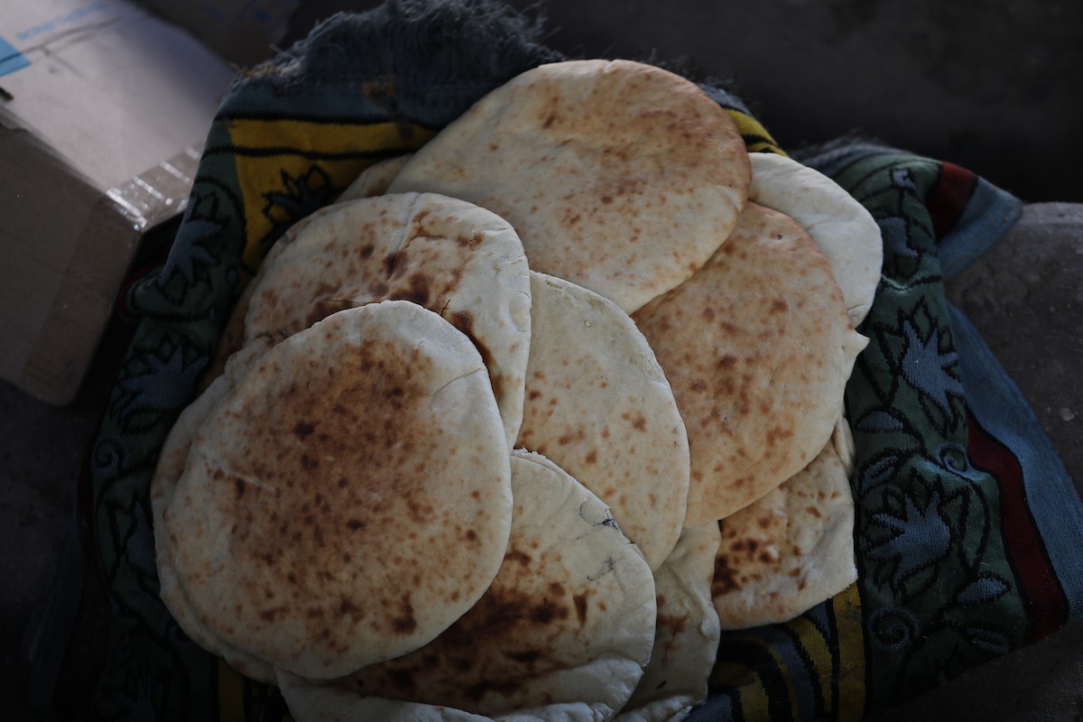 مجموعة من النساء يعملن داخل مخبز أُنشئ في مخيم اليرموك للاجئين بمدينة غزة، ضمن مبادرة إنسانية بالشراكة مع اللجنة الدولية للصليب الأحمر. تهدف المبادرة إلى تخفيف الأعباء المعيشية عن النساء النازحات، لا سيما خلال شهر رمضان. مدينة غزة، 25 فبراير/شباط 2026. تصوير: عمر أشتوي