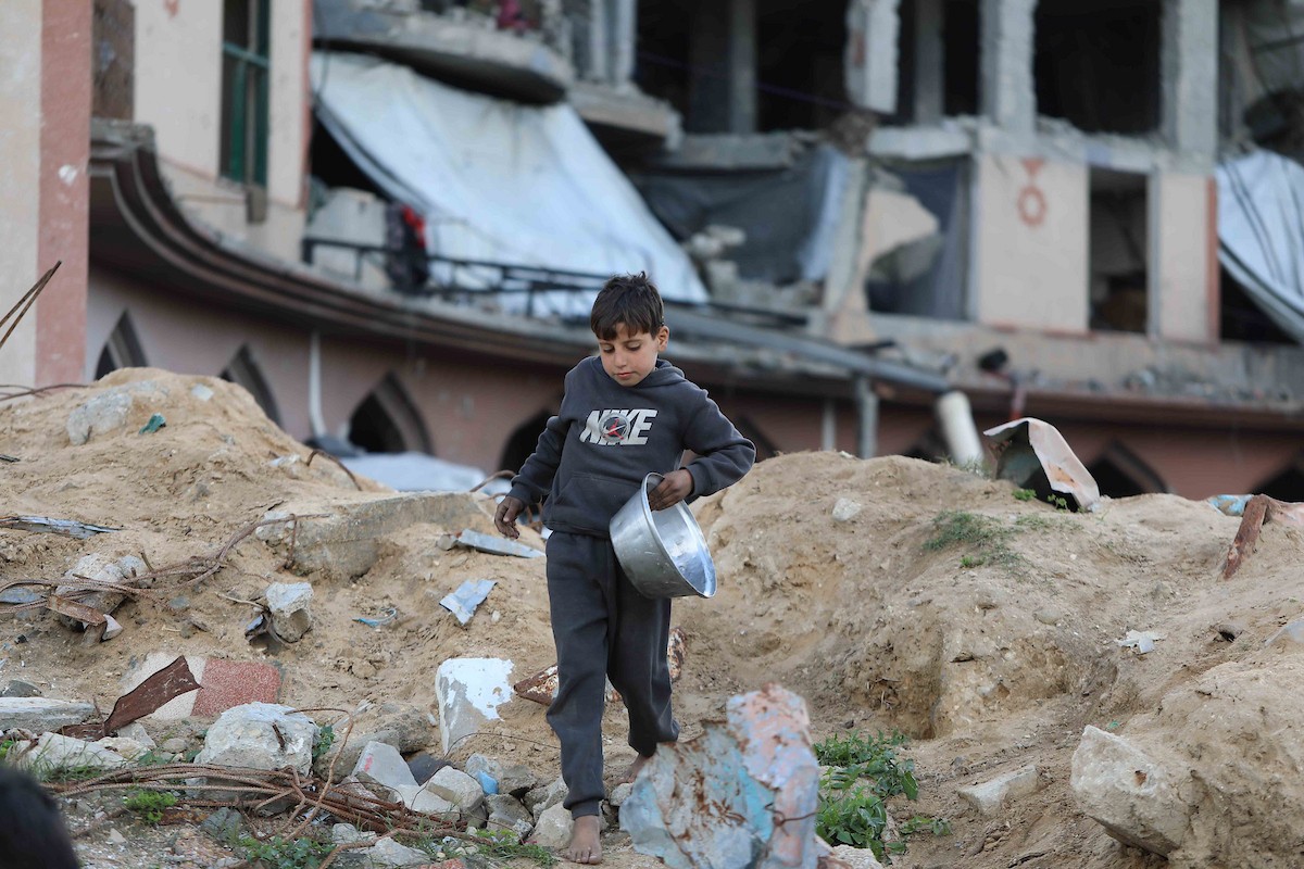 تجمع فلسطينيون نازحون، بينهم أطفال ونساء، حاملين أوعية طعام لتلقي وجبات ساخنة وزعتها جمعيات خيرية قبل الإفطار في مدينة غزة في 27 فبراير/شباط 2026.صورة: عمر أشتوي