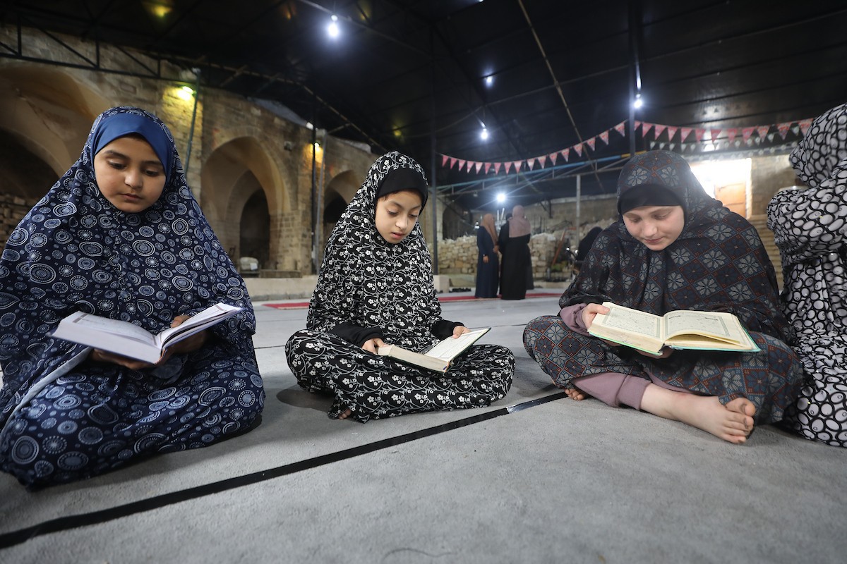 أطفال فلسطينيون يتلون ويحفظون القرآن الكريم داخل الجامع العمري الكبير في مدينة غزة خلال شهر رمضان. وقد تضرر الجامع العمري القديم بشدة جراء الهجمات الإسرائيلية خلال حرب غزة في 26 فبراير/شباط 2026. صورة: عمر أشتوي